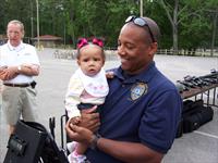 Officer Cedric Morris and daughter Kaiya.   Background-Councilman Holland